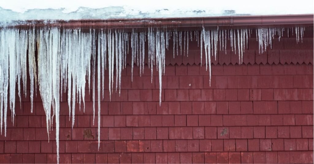 Ice buildup inside clogged gutters causing roof and fascia damage in Snellville homes-ice dam