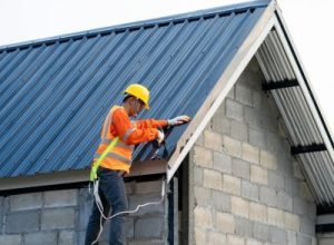 Roofing contractors installing new metal roof panels – Legends Restoration and Group