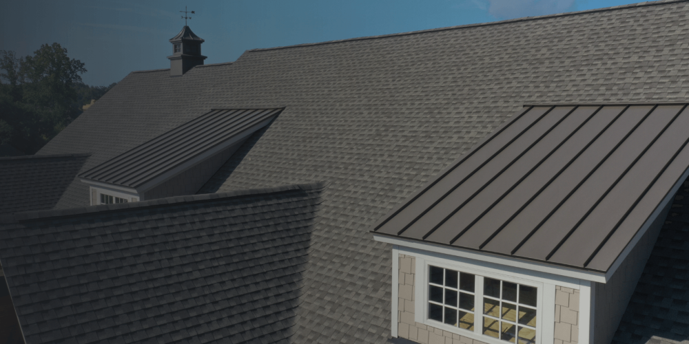Large roof with asphalt shingles and metal panels on a residential home
