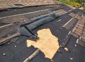 Damaged roof with broken shingles, roof repair service by Legends Restoration and Group